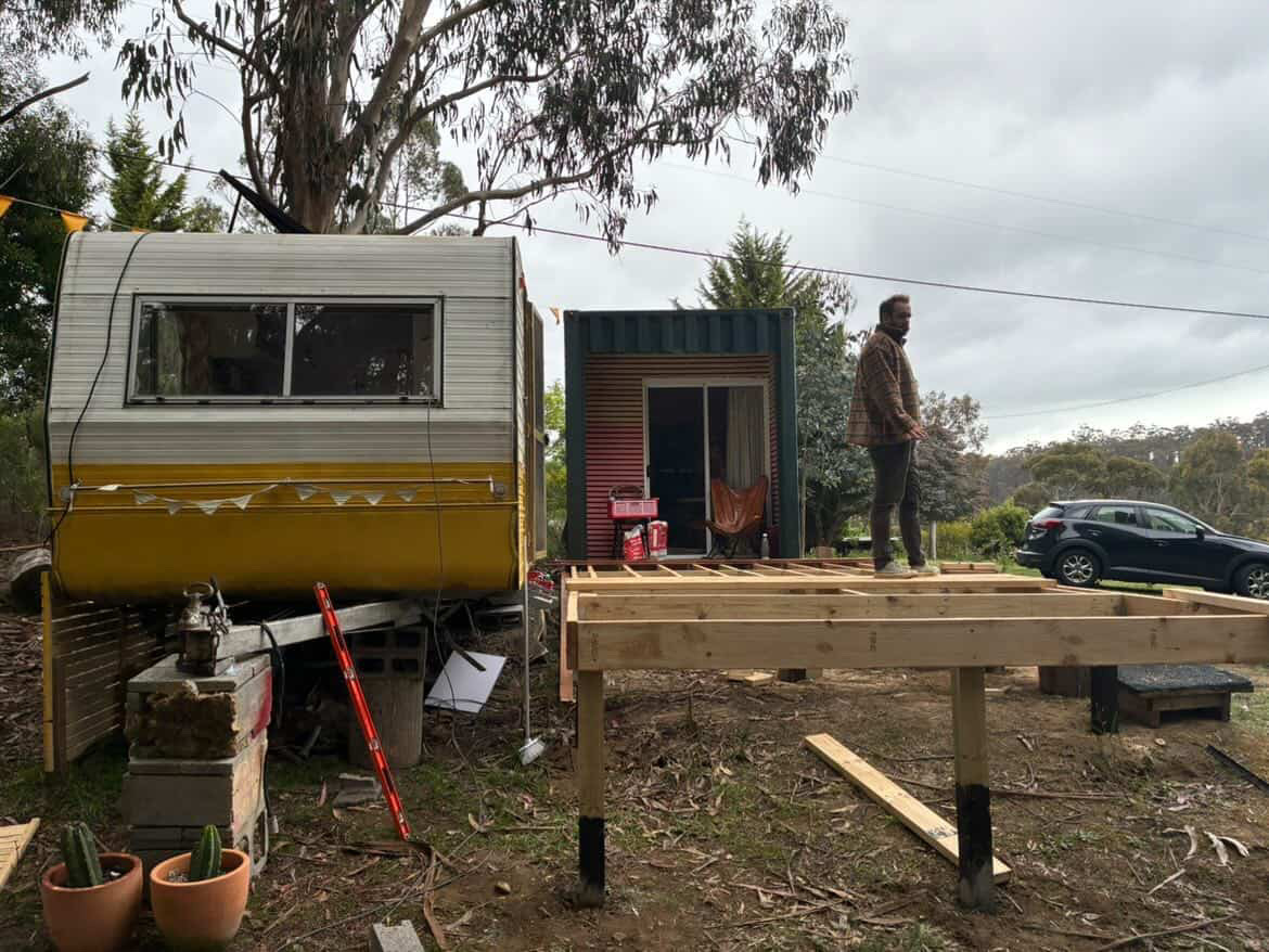 Property overview — caravan, work womb, and deck frame under construction